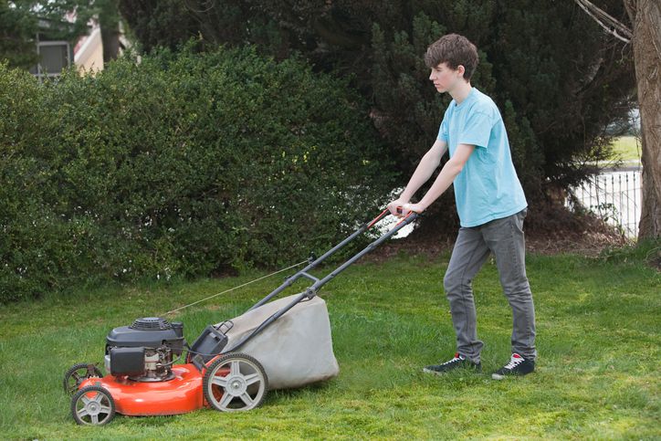 teen mowing yard